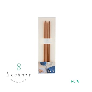 May include: A set of eight wooden knitting needles in a clear plastic package. The package has a white label with the text "8 Seeknit" on it. The needles are all the same size and are arranged in a row. The needles are made of natural wood and have a smooth finish.