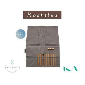 Op de afbeelding: Een grijze canvas rolhoes met de tekst "Koshitsu" erop gedrukt. De hoes is open en bevat een set houten breinaalden en een set ronde breinaalden. De hoes heeft ook een label met de tekst "Seeknit Curve".