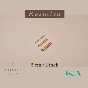 May include: Four wooden knitting needles with gold tips, each 5 cm (2 inches) long, are shown against a neutral backdrop. The image includes the text "Koshitsu" and "Seeknit", along with the measurement.