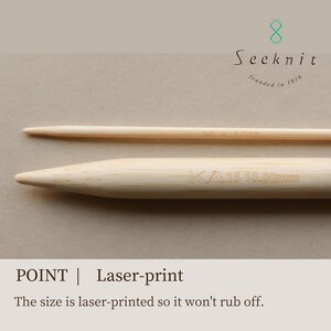 May include: Two light-colored bamboo knitting needles with a smooth, tapered point. The larger needle features laser-printed text reading KA 15 10.00mm. The brand logo Seeknit founded in 1916 is visible at the top. Text below reads POINT | Laser-print.