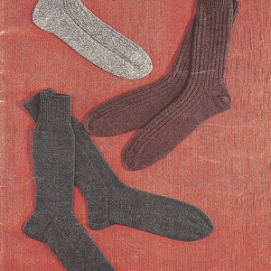 Peut inclure: Trois paires de chaussettes de couleurs et de motifs différents. Une paire est grise avec un motif texturé, une paire est marron foncé avec un motif côtelé et une paire est gris foncé avec un motif côtelé.