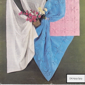 Puede incluir: Tres mantas de bebé de punto en blanco, azul y rosa. Las mantas están hechas con un delicado punto de tejido y presentan un diseño floral. El texto "DK/4ply/3ply" es visible en la esquina inferior derecha de la imagen.