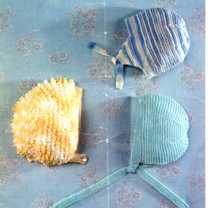 May include: Three knitted baby hats in different colors and textures. One hat is blue and white striped, one is light blue, and one is yellow and white.