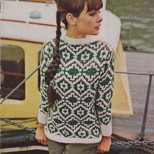 May include: A white sweater with a green and brown geometric pattern. The sweater has a crew neck and long sleeves.