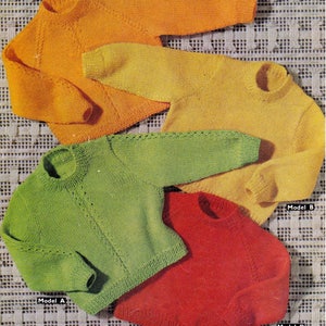 Peut inclure: Quatre pulls tricotés de différentes couleurs : orange, jaune, vert et rouge. Les pulls sont disposés sur une surface en crochet blanc. Les pulls sont étiquetés avec les mots « Modèle C », « Modèle B », « Modèle A » et « Modèle D ».