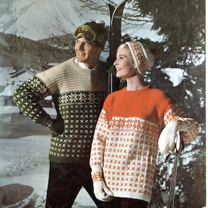 May include: A couple wearing matching knit sweaters with a traditional Scandinavian pattern in red, white, and green. The sweaters have a crew neck and long sleeves. The couple is standing in a snowy winter scene with a mountain in the background.