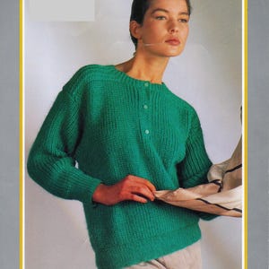 Peut inclure: Une femme porte un pull vert tricoté avec une texture côtelée et trois boutons au col. Le pull fait partie d'un catalogue de mode vintage, avec le texte "ECLIPSE DK" en haut. Tour de poitrine 86-102cm.