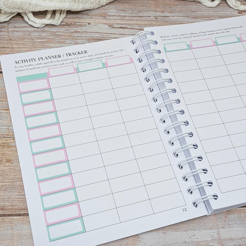 Puede incluir: Un planificador y rastreador de actividades con encuadernaci&oacute;n en espiral, p&aacute;ginas blancas y l&iacute;neas de cuadr&iacute;cula negras. La p&aacute;gina izquierda se titula ACTIVITY PLANNER / TRACKER e incluye columnas con encabezados rectangulares en verde claro y rosa.