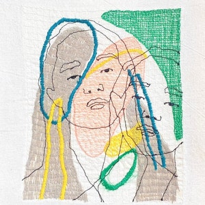 May include: Embroidered artwork featuring a stylized portrait of a person with overlapping lines and shapes in shades of gray, yellow, green, and blue.