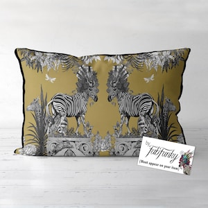 May include: Mustard yellow rectangular cushion featuring a black and white zebra design. The cushion has a black border and includes a tag that says "by FabFunky". The design includes floral and botanical elements.