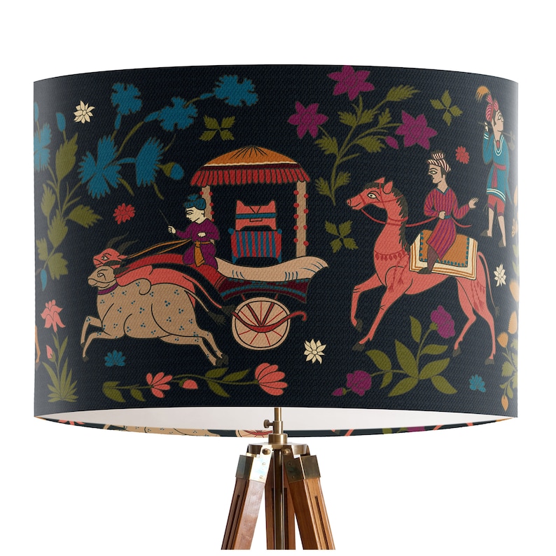 May include: A black lampshade with a colorful Indian-inspired design featuring a carriage pulled by a bull, a horse with a rider, and floral motifs.