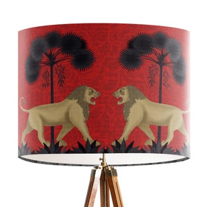 May include: A red lampshade with a black and gold design featuring two lions facing each other. The lions are surrounded by black palm trees and a red floral pattern.