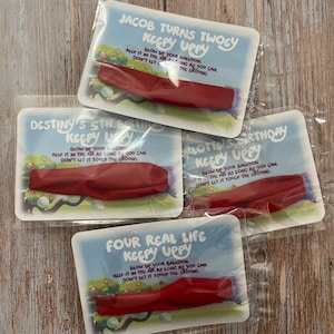 May include: Four colorful cards with red balloons and the text "Keepy Uppy" on each. The cards have different names and ages on them, including "Jacob Turns Twoey", "Destiny's 5th Birthday", "Klottie's Birthday", and "Four Real Life Keepy Uppy".