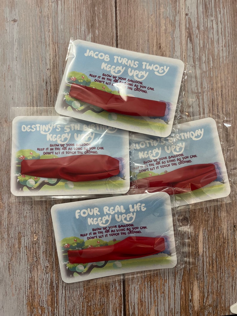 May include: Four colorful cards with red balloons and the text "Keepy Uppy" on each. The cards have different names and ages on them, including "Jacob Turns Twoey", "Destiny's 5th Birthday", "Klottie's Birthday", and "Four Real Life Keepy Uppy".