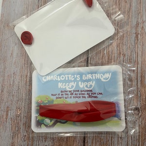 May include: A red balloon with the text "CHARLOTTE'S BIRTHDAY KEEPY UPPY" and instructions to blow up the balloon, keep it in the air as long as you can, and don't let it touch the ground.