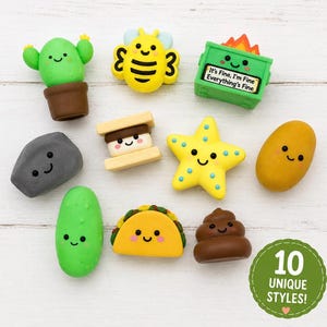 May include: A collection of ten small, colorful erasers featuring various characters and objects, including a green cactus, a yellow bee, a green dumpster with the text It's Fine, I'm Fine Everything's Fine, a gray rock, a s'more, a yellow star, a potato, a green pickle, a taco, and a brown swirl.