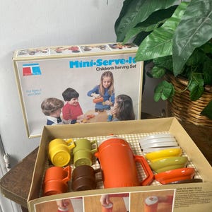 May include: A vintage Mini-Serve-It children's serving set in its original box. The set includes a pitcher, cups, plates, and bowls in shades of orange, yellow, brown, and green. The box features a picture of children using the set.