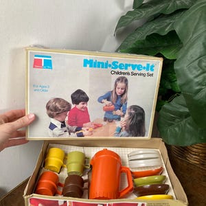 May include: A vintage Mini-Serve-It Children's Serving Set in a box with a picture of children playing. The set includes a pitcher, cups, bowls, and plates in orange, brown, yellow, and green.