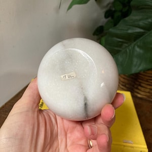 May include: White marble sphere with a small label that says "IT U.S."