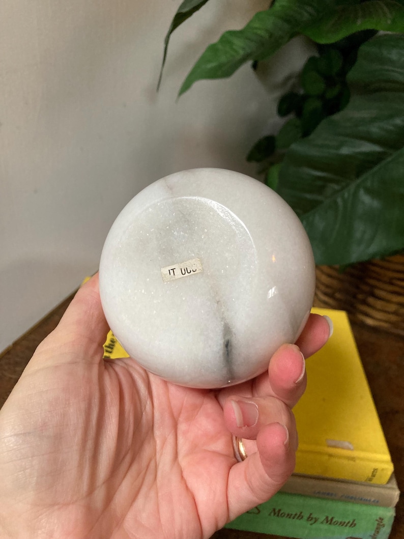 May include: White marble sphere with a small label that says "IT U.S."