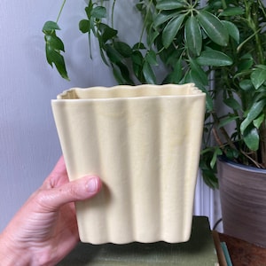 Pale yellow ceramic vase.