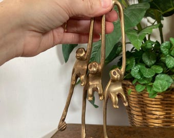 Three brass monkey hangers