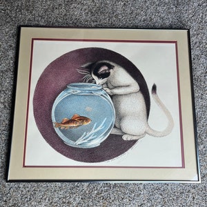 May include: A framed print of a white cat looking into a fishbowl with a goldfish inside. The cat is sitting on a purple background with the text "Is that you I feel?" written below the cat.