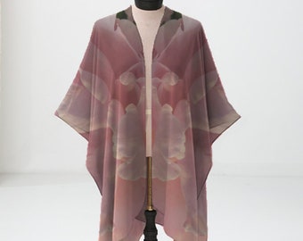 May include: A pink and white floral print kimono with a long, flowing silhouette. The kimono is draped over a black mannequin stand.