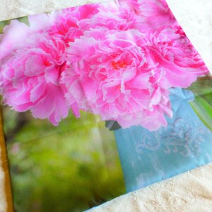 May include: A pink and white floral pillow cover with a blue and white patterned background. The pillow cover features a close-up of pink peonies.