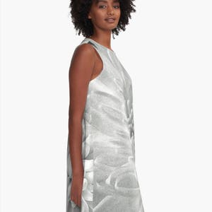 May include: A sleeveless dress with a black and white floral print. The dress has a scoop neck and a loose fit.