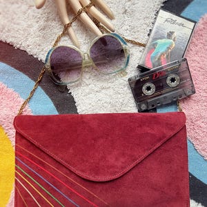 Cartera de hombro estilo sobre de ante color sangre de los años 80 con detalle de arcoíris