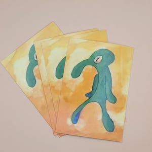 May include: Four watercolor prints of a green cartoon character with a long neck and one eye. The character is walking on a yellow background with white and orange accents.