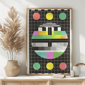 May include: A black and white poster with a colorful television test pattern in the center. The pattern is surrounded by a grid of black squares. There are four colored circles around the pattern: red, yellow, green, and pink.