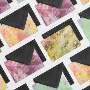 May include: A set of colorful envelopes with floral patterns. The envelopes are black on the outside and have a variety of colorful floral designs on the inside.