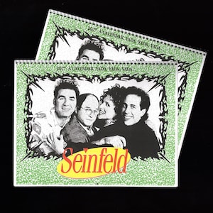May include: A 2027 wall calendar featuring a black and white photograph of the four main characters from the television show Seinfeld. The calendar has a light green background with a dark, jagged border and the text 2027 A CALENDAR, YADA, YADA, YADA.