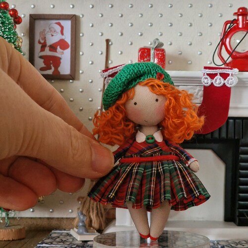 Pequeña muñeca de trapo con vestido escocés