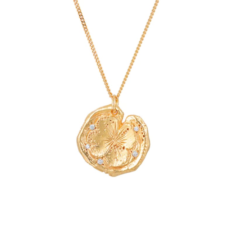 May include: A gold necklace with a large, round pendant. The pendant is textured and has a starburst design with four small diamonds set in the center. The necklace is on a white background.