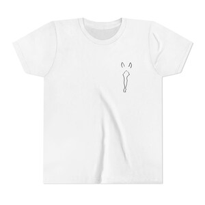 May include: White t-shirt featuring a minimalist black line drawing of a figure. The graphic is positioned on the upper left chest area. The shirt has a crew neck and short sleeves.