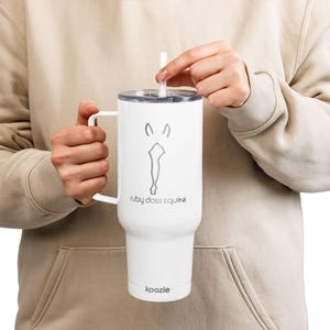 May include: White insulated tumbler with a handle and a straw. The tumbler features a gray horse head design and the text "ruby doss EQUINE". The brand name "koozie" is printed at the bottom.
