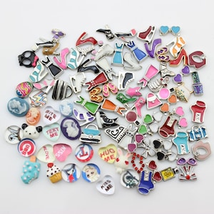 Può includere: Una collezione di ciondoli smaltati colorati con vari disegni, tra cui cuori, scarpe, abiti, animali e parole come "Bite Me", "Text Me", "Love" e "Hug Me".