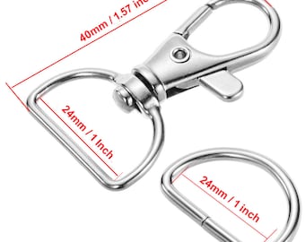 Może przedstawiać: Zestaw srebrnych metalowych elementów okuć, w tym obrotowy karabińczyk o długości 40 mm i D-ring, oba z otworem 24 mm. Przeznaczone do różnych projektów rzemieślniczych i DIY.