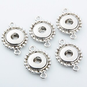 May include: Five silver-toned metal snap button connector charms with a beaded edge. Each charm has two loops for attaching to jewelry or other crafts.