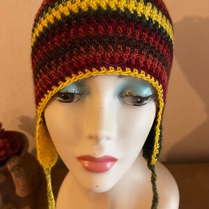 Charmant bonnet style péruvien avec ses cache oreilles sur le côté et ses petites nattes