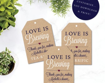 Puede incluir: Tres etiquetas de regalo de papel marrón con el texto "Love is Brewing" en letras azul marino. Cada etiqueta tiene un pequeño corazón rojo y el texto "Gracias por hacer la fiesta de [nombre] TEA-RRIFIC".