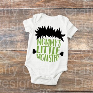 May include: White baby onesie with a green and black graphic that says "Mommy's Little Monster".