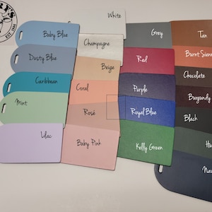 May include: A color chart with 20 different leather swatches. The swatches are arranged in two rows of ten. The colors include white, baby blue, dusty blue, caribbean, mint, lilac, champagne, beige, coral, rose, grey, tan, red, burnt sienna, purple, burgundy, royal blue, black, kelly green, hunter, and navy.