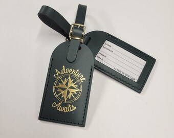 May include: Dark green leather luggage tag with a gold compass and the text "Adventure Awaits". The tag has a blank white label with the words "Name, Address, Phone, Email, Made in the USA".