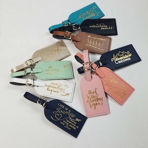 May include: Ten leather luggage tags with gold lettering. The tags feature various travel-themed quotes, including "Life is a Journey", "And so the adventure begins", and "The adventure begins".