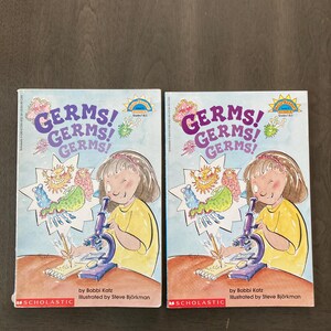May include: Two copies of the children's book "GERMS! GERMS! GERMS!" by Bobbi Katz, illustrated by Steve Bjorkman. The cover features a cartoon illustration of a girl using a microscope. The book is published by Scholastic.