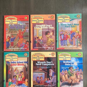 May include: Six children's books from "The Adventures of the Bailey School Kids" series are displayed. The covers feature colorful illustrations and titles like "Genies Don't Ride Bicycles" and "Wolfmen Don't Hula Dance."